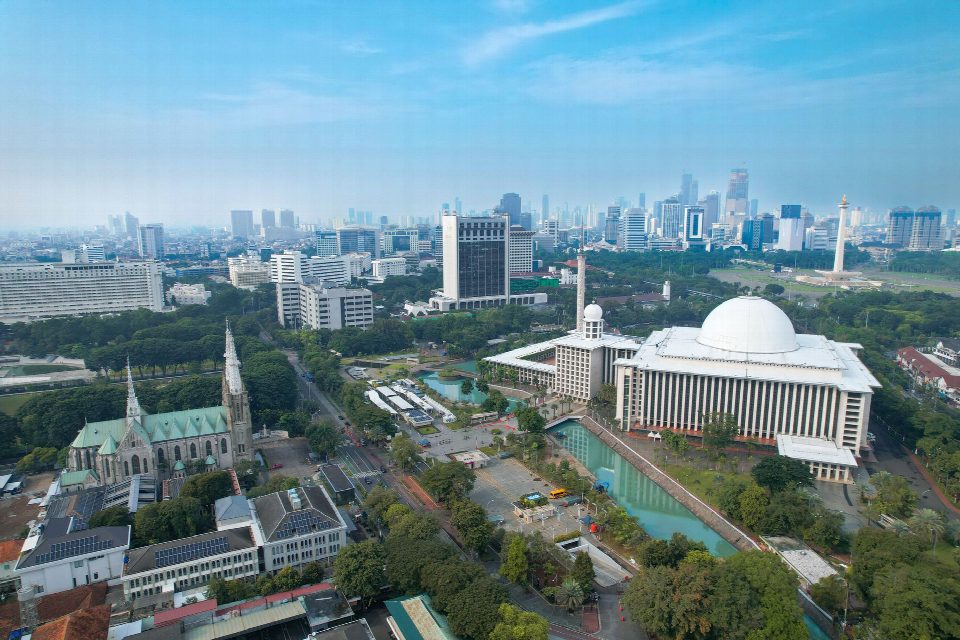 Stunning aerial shot of Istiqlal Mosque and Jakarta's modern skyline. Stunning aerial shot of Istiqlal Mosque and Jakarta's modern skyline.