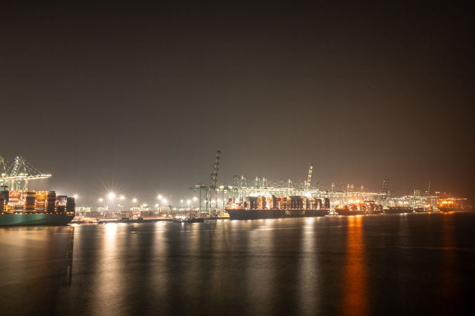 Luminous night view of a bustling industrial port with cargo ships. Luminous night view of a bustling industrial port with cargo ships.