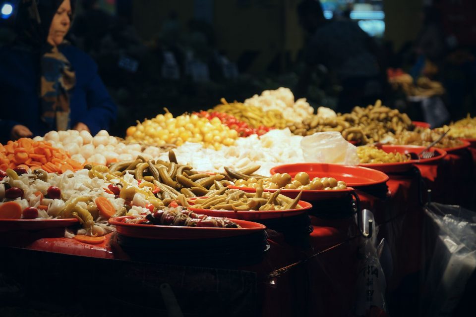 Vibrant assortment of pickles on display at an indoor market stall. Vibrant assortment of pickles on display at an indoor market stall.